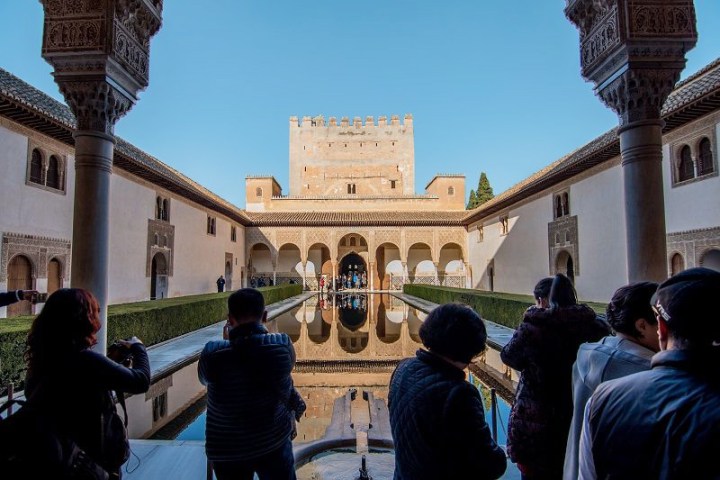 gente haciendo fotos a un patio de la Alhambra