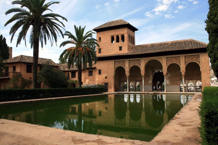 a large stone building with palm trees