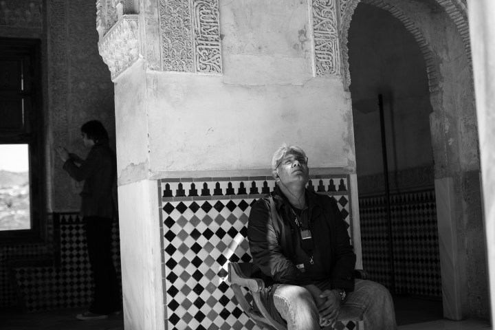 a man sitting on a bench in front of a building